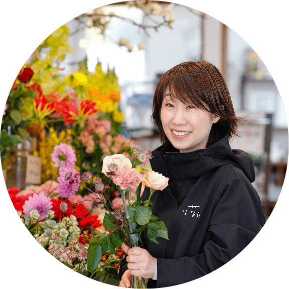 花屋の店内で花束を持って笑顔を見せるスタッフ女性と花のイラスト枠