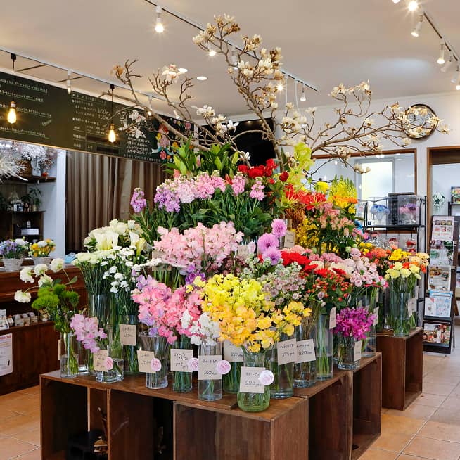 『はなも』店内中央に配置されたフラワーディスプレイ。桜やガーベラ、スイートピーなど多彩な生花が整然と並ぶ美しい売り場の様子