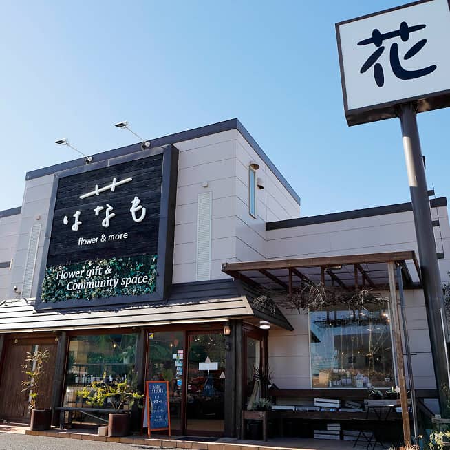 フラワーギフトとコミュニティスペースを併設した花屋『はなも』の外観。大きな看板と『花』の看板が目印のモダンな建物