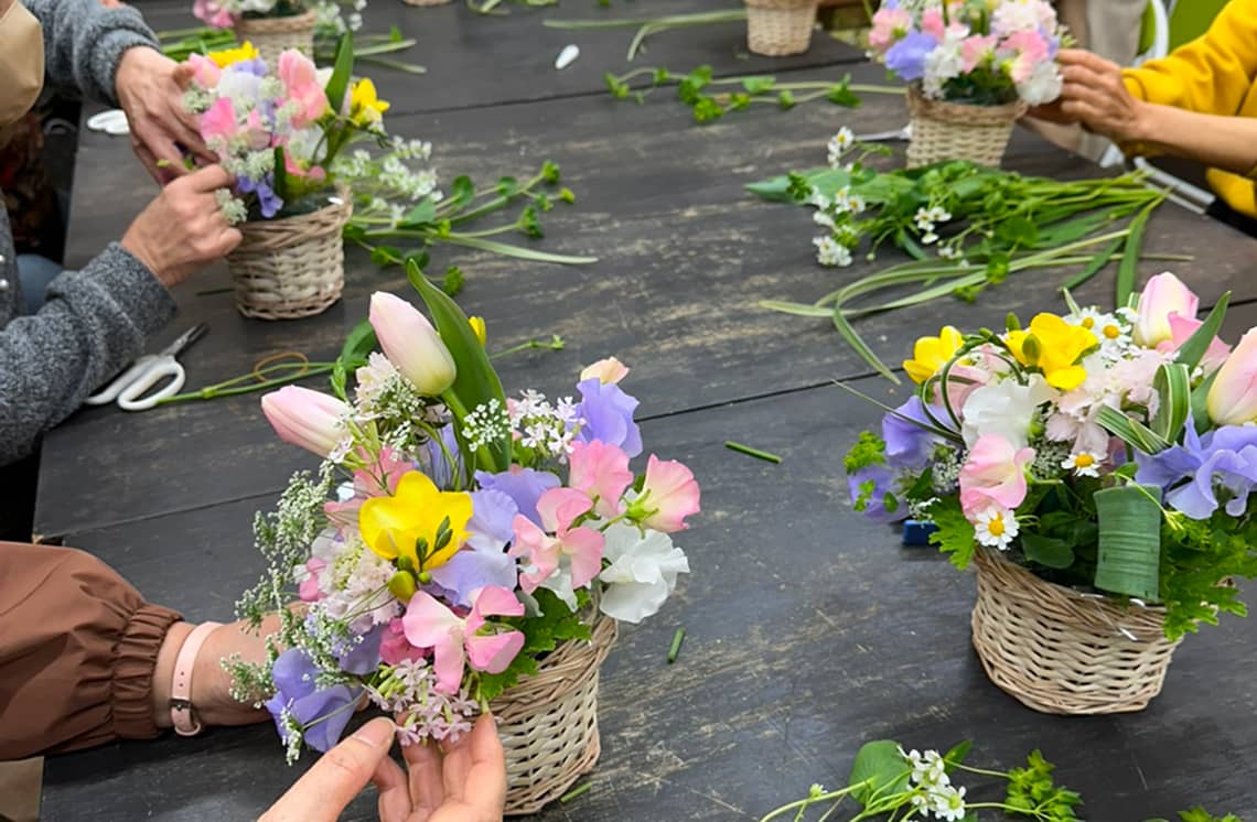 フラワーアレンジメント教室で花かごを作る参加者たち